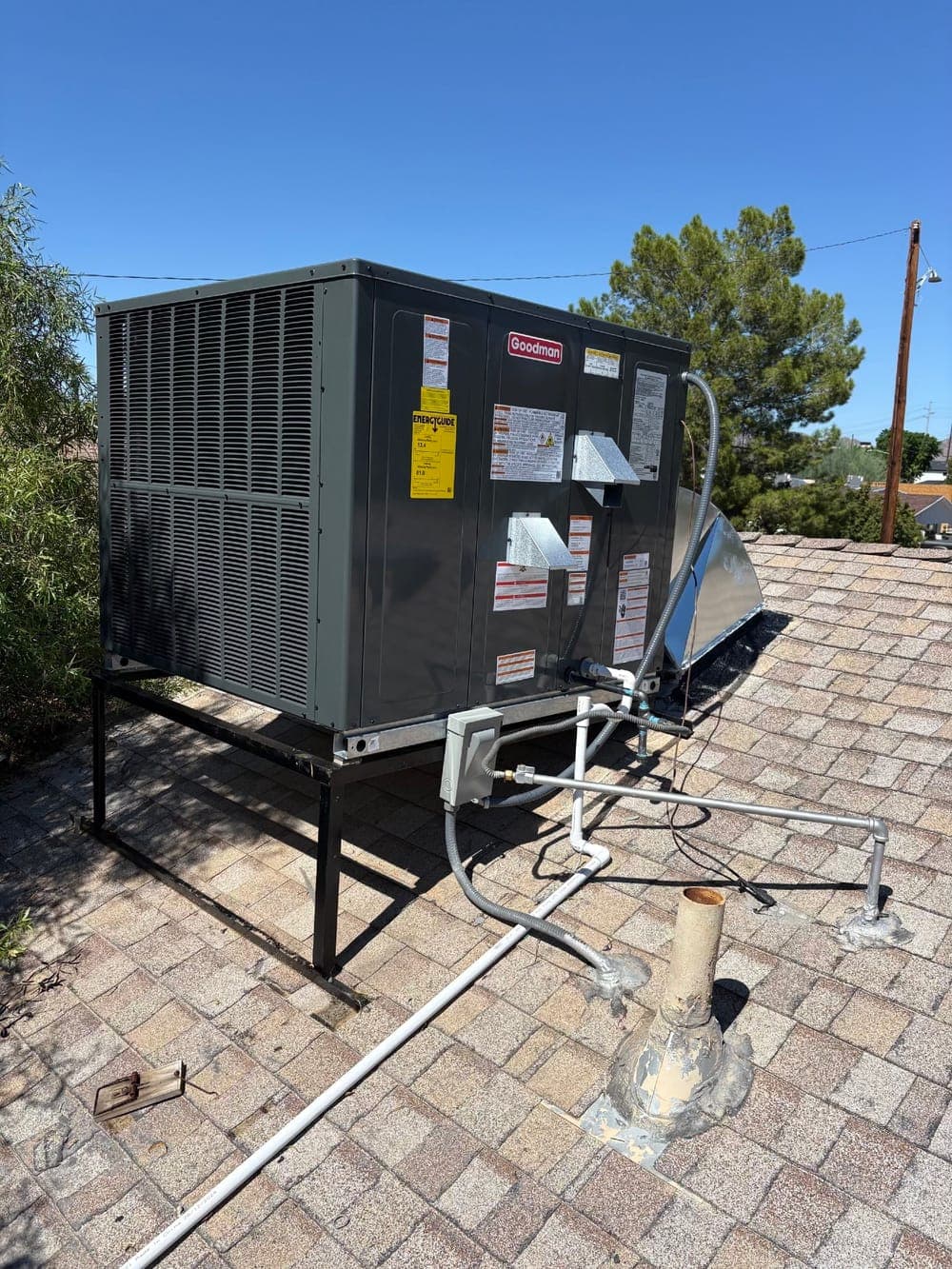 Goodman rooftop package air-conditioning unit on a steel stand during an Arizona install